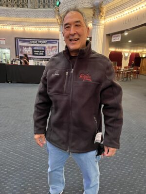 Man wearing the black Leonid & Friends Eddie Bauer full-zip fleece with red embroidered logo
